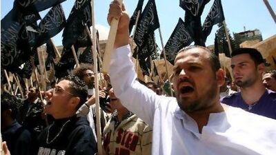 Supporters of pan-Islamic group Hizb al-Tahrir (Party of Liberation) wave the party's flags as they shout slogans during a protest against the Syrian regime in the northern Lebanese city of Tripoli on April 22.