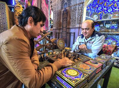 Komoliddin Abdullayev, right, and a friend plays chess on a handmade board from Uzbekistan at the Sheikh Zayed Heritage Festival. Victor Besa/The National