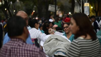 A patient is evacuated from a hospital during a powerful earthquake in Mexico City. Pedro Pardo / AFP