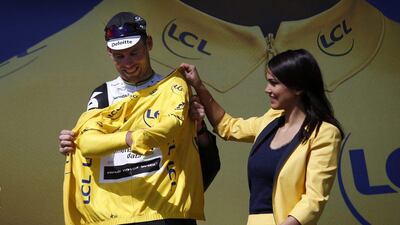 Team Dimension Data rider Mark Cavendish of Britain celebrates on the podium wearing the overall leader’s yellow jersey following the first stage of the 103rd Tour de France first stage of the Tour de France cycling race from Mont Saint-Michel to Utah Beach, France, Saturday, July 2, 2016. Kim Ludbrook / EPA