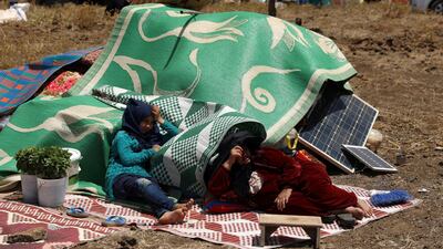 Internally displaced people from Syria's Deraa province sit with their belongings near the Israeli-occupied Golan Heights in Quneitra, Syria on June 29, 2018. Alaa Al Faqir / Reuters