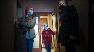 Russian pensioner Galina Prokopieva, 72, picks up a bag with products brought by volunteers in Moscow, Russia. AP Photo