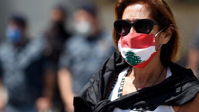 An Anti-government protester wears a mask as she takes part in a protest near the French embassy in Beirut. EPA