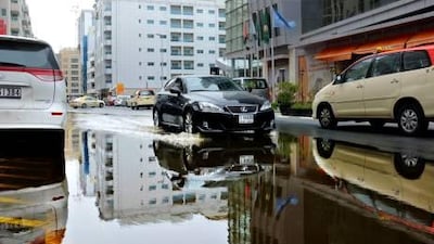 Motorists drive through large puddles left by overnight rain in Al Barsha.