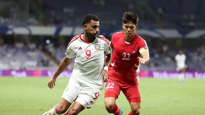UAE's Harib Abdalla vies for the ball with Kuk-Bom Kim of North Korea