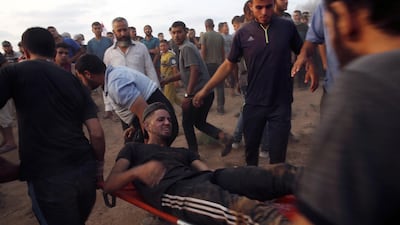 Medics and protesters evacuate a wounded demonstrator near the Gaza Strip border with Israel, during a protest east of Gaza City. AP Photo