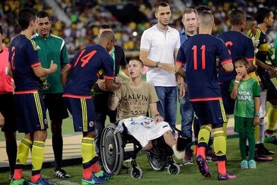 In this file photo from January 25, 2017, former Chapecoense goalkeeper Jackson Follmann, in the wheelchair, greets Colombia players before a friendly match at the Nilton Santos stadium in Rio de Janeiro, Brazil, in tribute to Chapecoense team members who died in a plane crash in Colombia last November. Silvia Izquierdo / AP Photo
