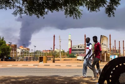 An otherwise normal street in Khartoum on Thursday apart from the smoke rising from a battle behind buildings in the background. AFP