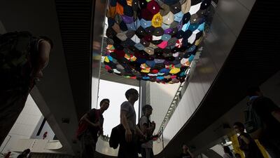 Protesters walk under an art installation made from umbrellas by a local artist outside the government headquarters in Hong Kong October 3, 2014. Reuters