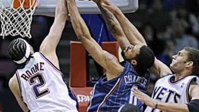 New Jersey Nets' Josh Boone blocks a shot by Charlotte Bobcats' Tyson Chandler with help from Brook Lopez.
