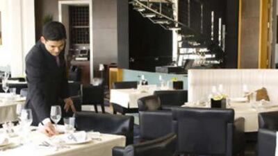 A waiter sets a table at the Vu restaurant in the Emirates Tower Hotel in Dubai.