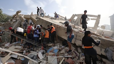 Rescue workers remove rubble as they search for survivors trapped under a collapsed building. Getty Images