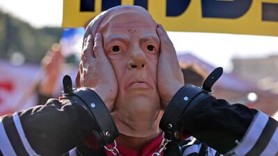 A demonstrator wearing a mask representing Prime Minister Benjamin Netanyahu gestures during a demonstration outside the court, as his corruption trial resumes in occupied east Jerusalem. AFP