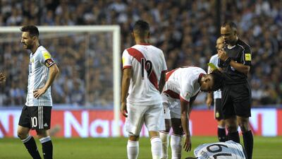Brazilian referee Wilton Pereira Sampaio yellow cards Peru's Renato Tapia (2-R) as Argentina's Ever Banega lies on the ground during their 2018 World Cup qualifier football match in Buenos Aires on October 5, 2017. / AFP PHOTO / Alejandro PAGNI