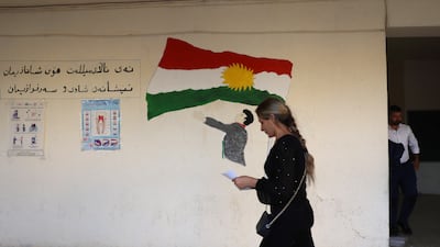 A woman walks past a Kurdish flag in Erbil. Iraq's Kurds came under attack by Saddam Hussein's government during the 1980s. EPA