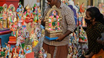 A vendor arranges idols representing deities and characters from Hindu mythology at a stall, during Navratri in Chennai. AFP