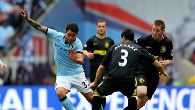 Carlos Tevez of Manchester City skips past Wigan's Antolin Alcaraz. Getty