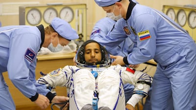 Russian Space Agency experts help Hazza Al Mansouri, member of the main crew of the expedition to the International Space Station, to sit during an inspection of his space suit prior the launch of Soyuz MS-15 space ship on Wednesday. Dmitri Lovetsky / AP