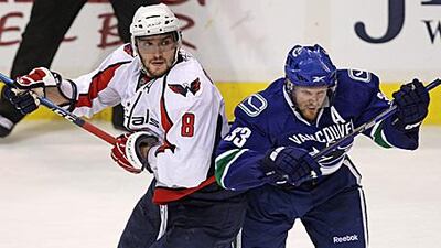 Alexander Ovechkin, left, is checked by the Canucks' Henrik Sedin. The Capitals' player failed to score as the Canucks won 3-2.