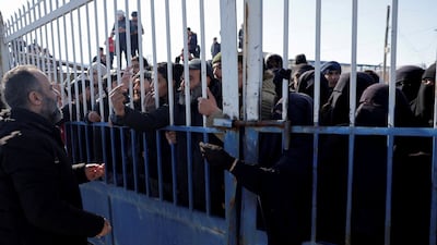Detainees talk with people through a gate after the Syrian government took control of Al Hol from the SDF. Reuters