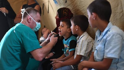 A Russian medic checks a Syrian child in a tent set up at the Abu Duhur crossing. AFP