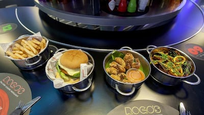 The wide range of dishes at ROGO's include, from left, the Tornado Burger, fried shrimp and seafood linguine. Mona Al Marzooqi / The National