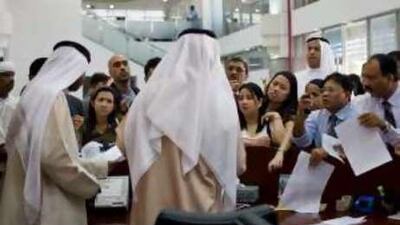 Two Emirates Identity Authority staff members in Dubai are heavily outnumbered by applicants vying for their attention.