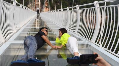 A couple take pictures on the bridge.