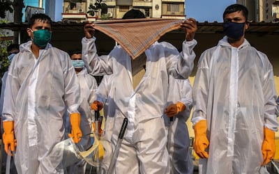 Indian police in protective gear prepare themselves for a patrol in the streets of a Covid-19 hotspot area in Mumbai, India. EPA