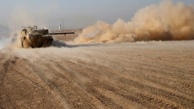Iraqi soldiers fire a tank shell during clashes with ISIL fighters.