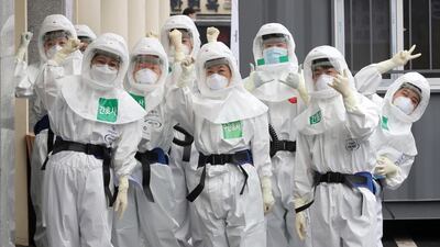 Medical staff members gesture as they arrive for a duty shift at Dongsan Hospital in Daegu, South Korea. Newsis via AP