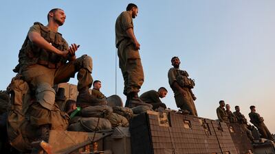 Israeli soldiers stand on an armoured personnel carrier near the Israel-Gaza border, in southern Israel. Reuters