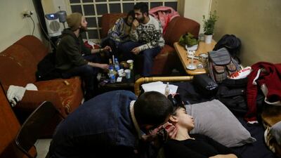Aya, 24, a chef, rests as she gets a tattoo on her neck at her friend's house in Damascus. Reuters