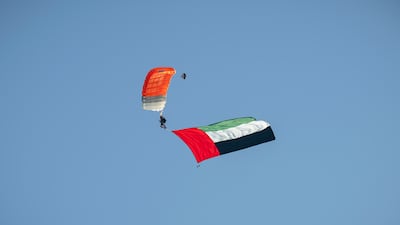 A parachutist carries the Emirates flag
