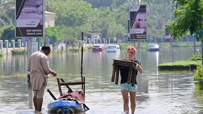 UAE residents unload salvaged belongings from a canoe following the heavy rain in Dubai. AFP