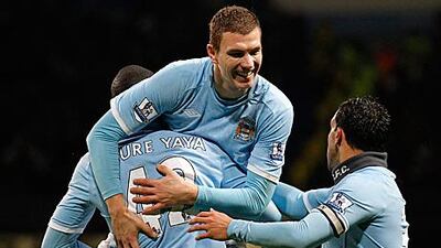 Edin Dzeko, centre, is congratulated by Yaya Toure, left, and Carlos Tevez after providing Yaya with the assist for Manchester City's third goal against Wolves.
