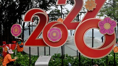 Workers tend to flowers next to New Year's Eve display in Hanoi, Vietnam. AFP