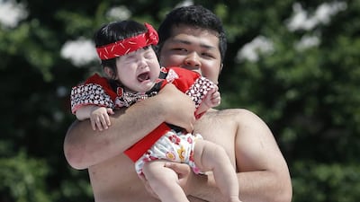 epA baby, held by an amateur sumo wrestler, breaks into tears during the Nakizumo or crying baby contest at Sensoji Temple in Tokyo, Japan, 30 May 2015. Kiyoshi Ota / EPA