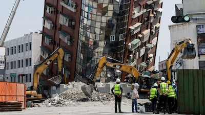 Workers carry out operations at the site where a building collapsed. Reuters