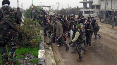 Syrian pro-government forces celebrate on a street in the town of Sheikh Maskin, southern Deraa province, on January 26, 2016 after they retook the strategic town from rebel forces. AFP