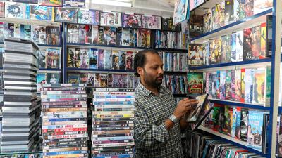 Musthafa Kamal, the owner of Blue Diamond Video, arranges returned DVDs at his store behind Madinat Zayed Shopping Centre. Chris Whiteoak / The National