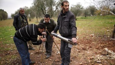 Free Syrian Army fighters prepare a homemade missile before they launch it towards the military airport in Aleppo.