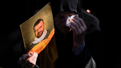 A woman cries as mourners bury the bodies of nearly 100 Lebanese people killed during the war between Israel and Hezbollah in the largest mass funeral in Lebanon, held in the southern village of Aitaroun. AP