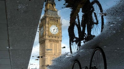 The Queen Elizabeth Tower, better known as Big Ben, is reflected in a London puddle as a cyclist rides by. The UK is continuing preparations to leave the EU. Leon Neal / AFP