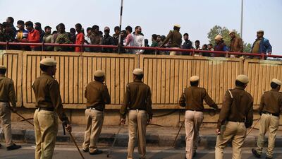 Police personnel move onlookers from a road after following a factory fire in Anaj Mandi area of New Delh. At least 43 people have died in a factory fire in India's capital New Delhi, with the toll still expected to rise. AFP