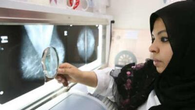 Dr Jalaa Taher examines x-rays at the National Health Screening Program for Women and Children.