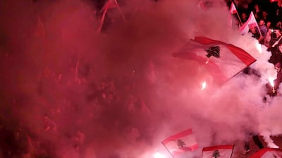 Anti-government protesters light flares and wave Lebanese national flag in Beirut. AP Photo