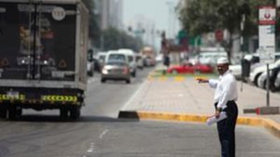 A man signals for a taxi along Airport Road in Abu Dhabi.