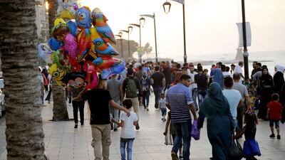 People walk along Beirut's corniche on the first day of the Eid Al Adha Islamic holiday. Lebanon's economy remains under pressure despite political progress. Anwar Amro / AFP