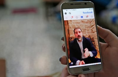 A woman watches the Facebook video of Syrian businessman Rami Makhlouf on her mobile in Syria's capital Damascus. AFP